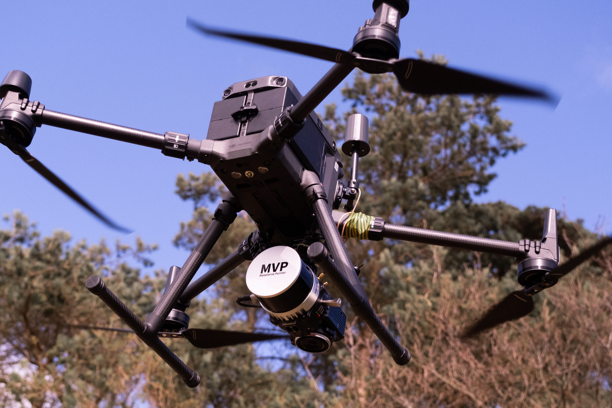 Commercial drone with camera flying outdoors, AlphaGeo survey equipment, blue sky, trees