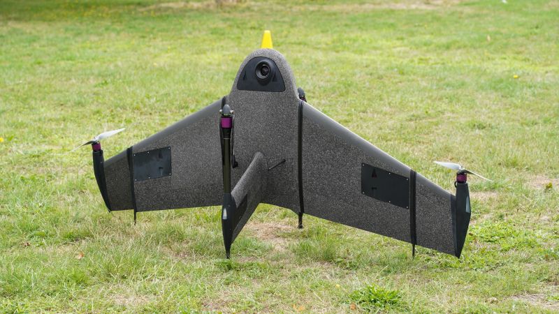 Commercial fixed-wing drone with propellers on grass, AlphaGeo UAV survey equipment