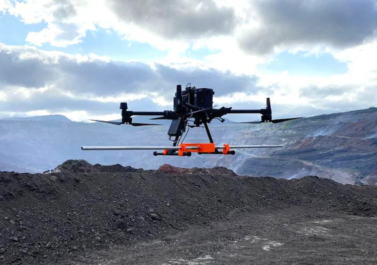 Industrial drone with sensor flying over open-pit mine, AlphaGeo survey equipment in use