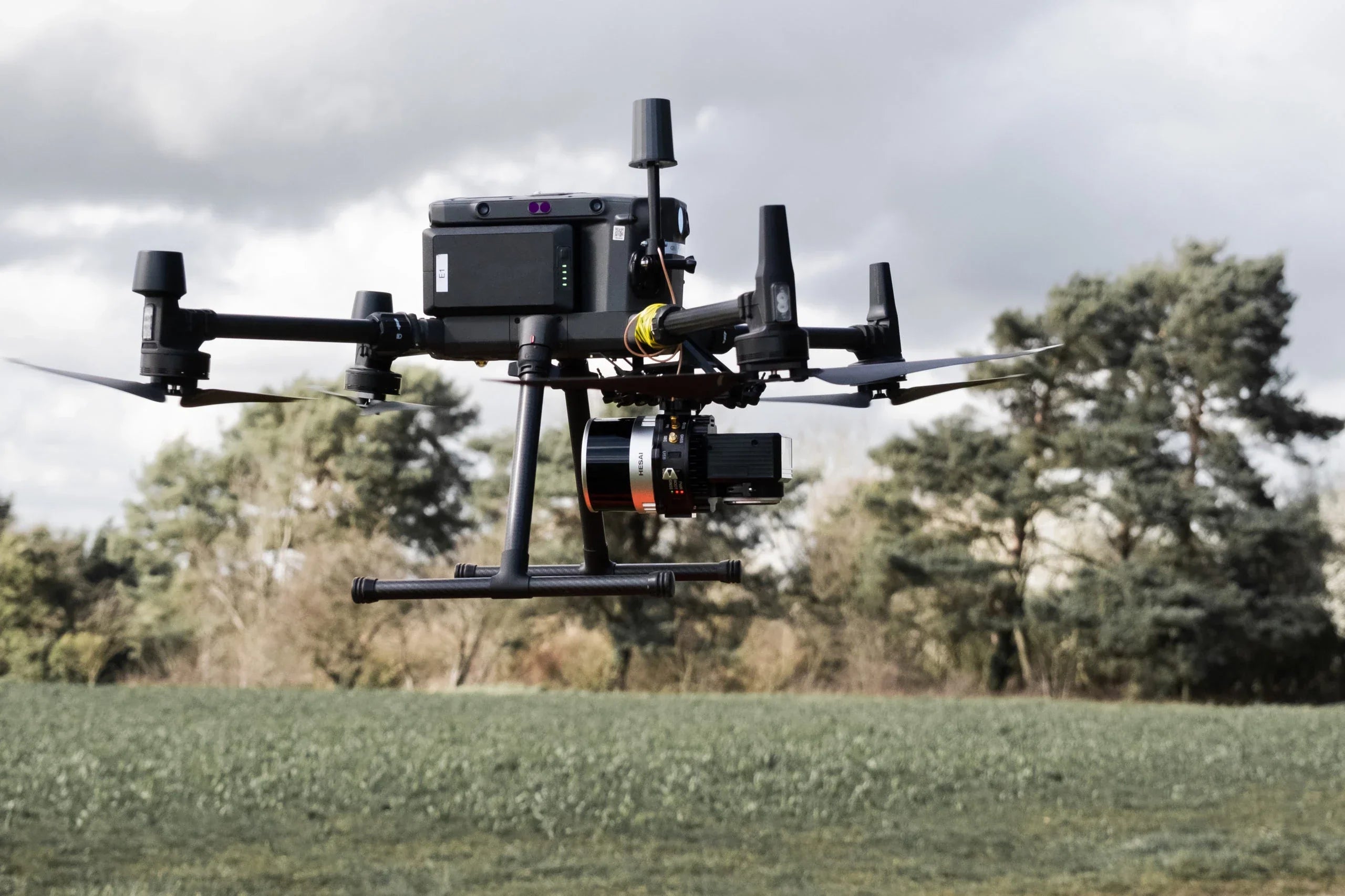 Professional commercial drone with camera flying over a field, outdoor survey equipment by AlphaGeo